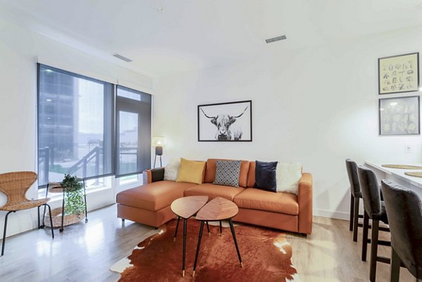 Cozy living room with plush seating and large windows at The Lydell Apartments