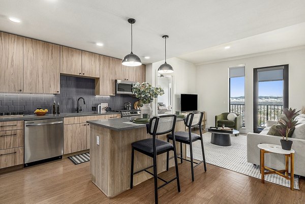 Modern kitchen with stainless steel appliances in One Seven Belleview Station Apartments