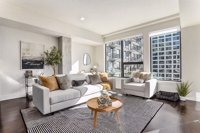 Living room with modern furnishings and large windows at One Seven Belleview Station Apartments, luxury living in the heart of the city