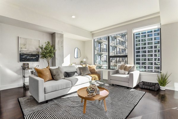 Living room with modern furnishings and large windows at One Seven Belleview Station Apartments, luxury living in the heart of the city