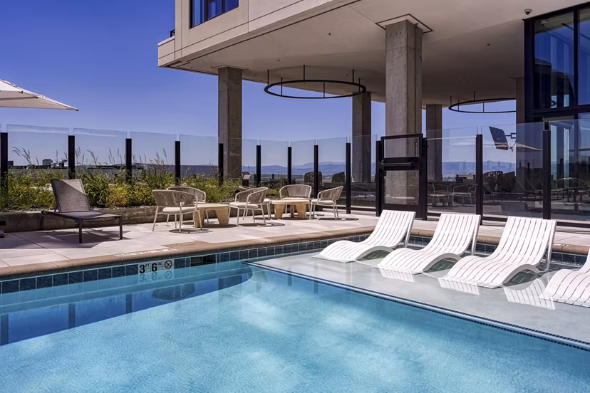 Lap pool with sleek seating at One Seven at Belleview Station Apartments, offering luxury relaxation for residents