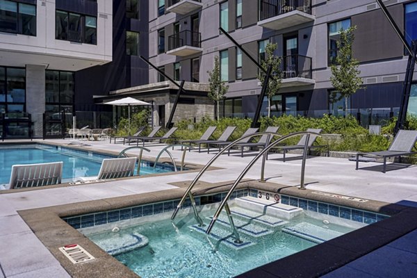 Scenic outdoor pool area at One Seven at Belleview Station Apartments in a tranquil setting, perfect for relaxation and recreation