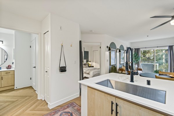 Open-concept kitchen with stainless steel appliances in Novi at Queen Anne Apartments
