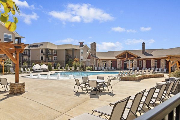 Resort-style pool with surrounding lounge chairs at Easton Place Apartments, offering luxury relaxation in a serene setting