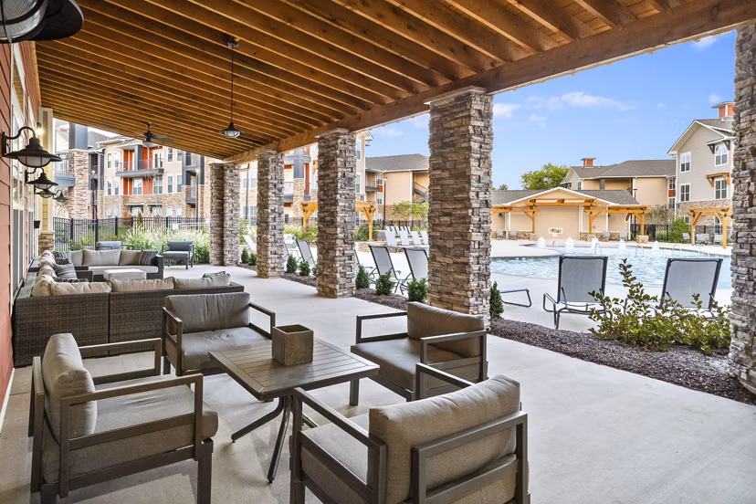 Spacious outdoor patio with modern seating at Easton Place Apartments featuring lush landscaping