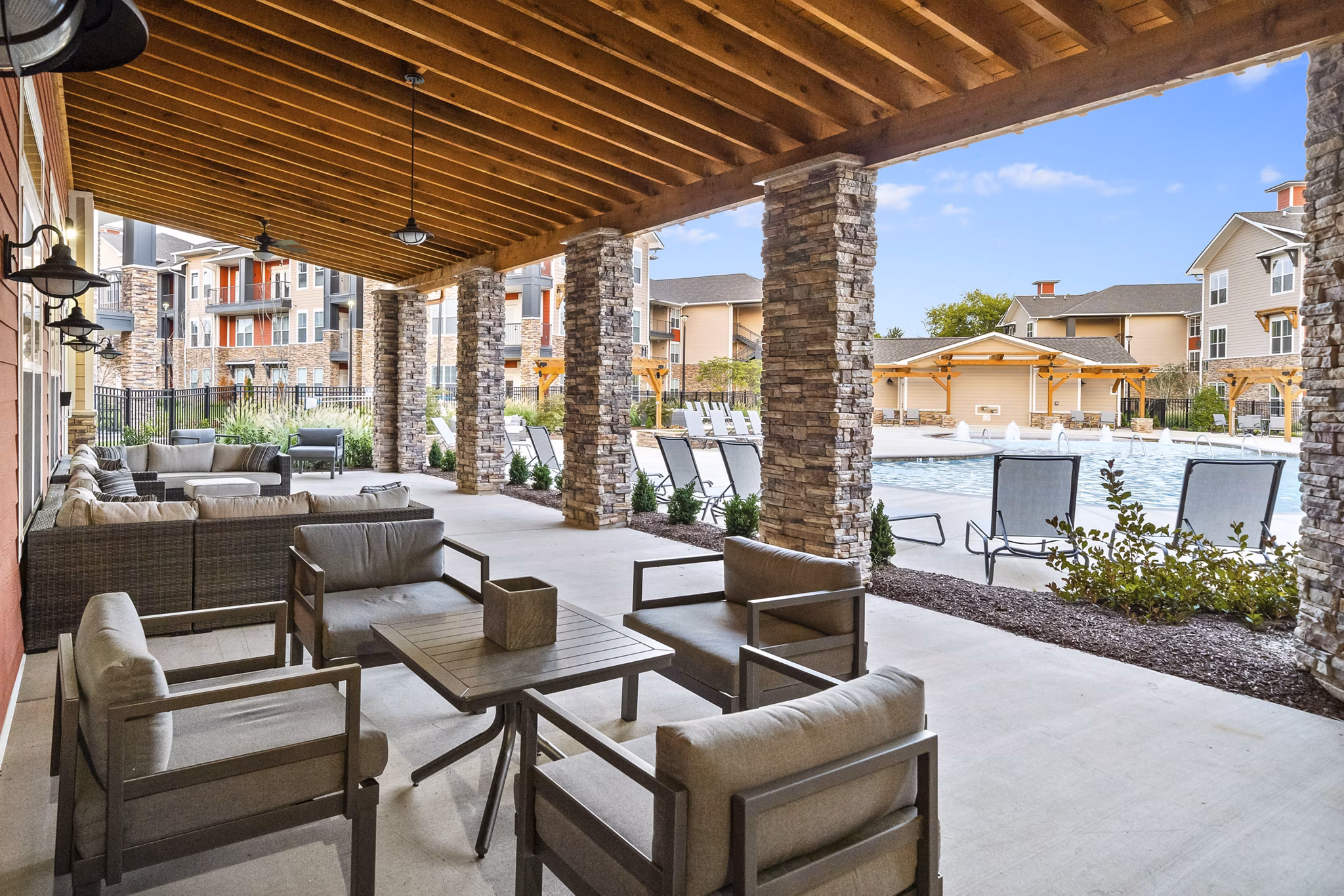 Spacious outdoor patio with modern seating at Easton Place Apartments featuring lush landscaping