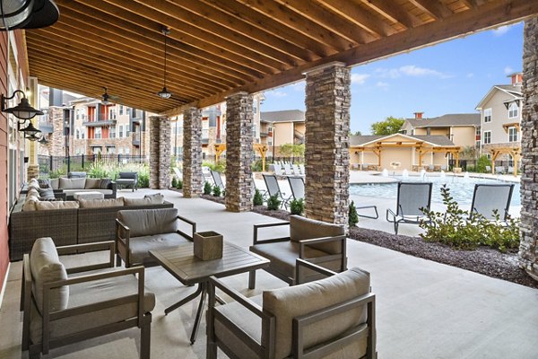 Spacious outdoor patio with modern seating at Easton Place Apartments featuring lush landscaping
