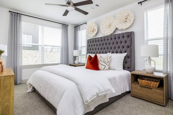 Cozy bedroom with plush bedding and natural light at Avelyn San Marcos luxury apartments