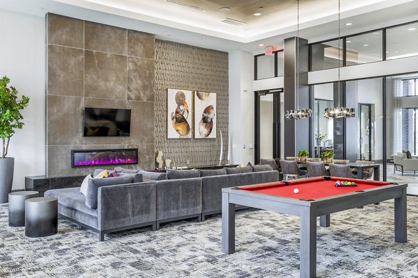 Clubhouse game room with pool table and lounge seating at Avelyn San Marcos Apartments