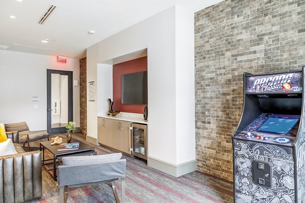 Clubhouse game room with pool table and lounge seating at Avelyn San Marcos Apartments