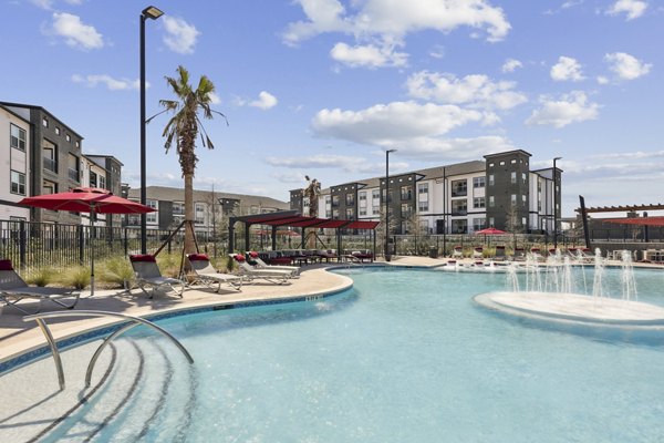 Pool with lounge seating at Avelyn San Marcos Apartments, offering luxury relaxation and modern design for residents