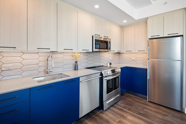 Modern kitchen with stainless steel appliances and granite countertops in Broadridge Apartments