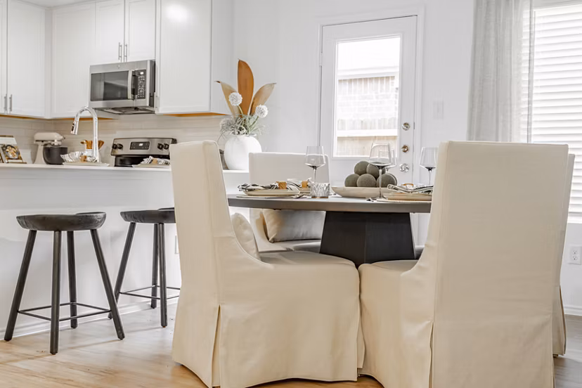 Dining area with elegant furnishings and large windows at Summerwell Wildcat Ranch Home Apartments