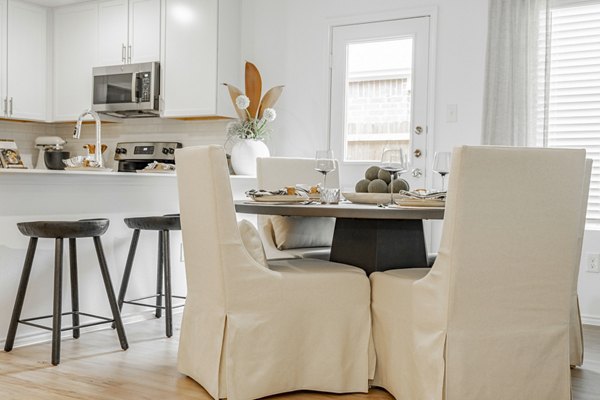 Dining area with elegant furnishings and large windows at Summerwell Wildcat Ranch Home Apartments