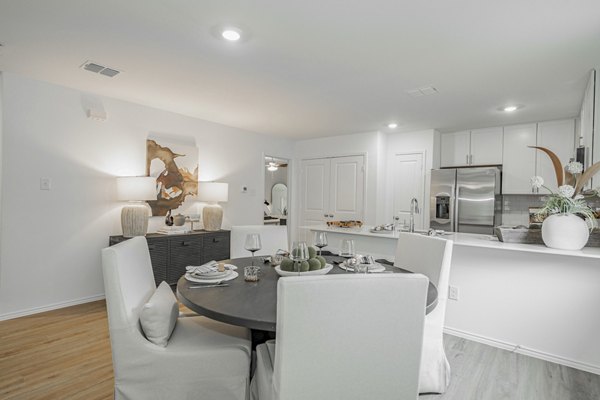 Dining room featuring elegant chandelier and large windows at Summerwell Wildcat Ranch Apartments, perfect for luxury living