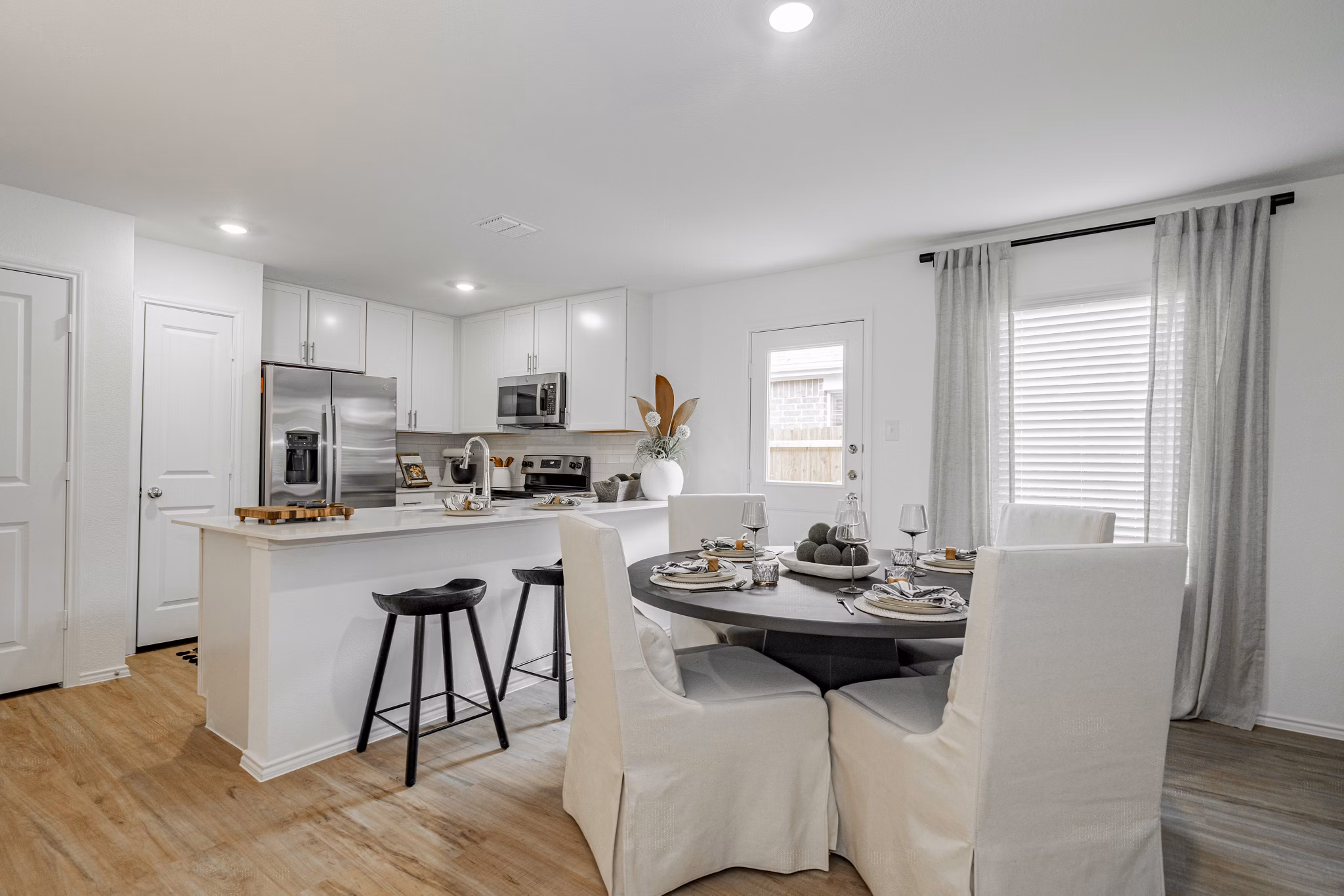 Dining room featuring elegant wooden dining set and modern chandelier at Summerwell Wildcat Ranch Home Apartments