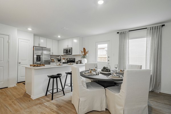 Dining room featuring elegant wooden dining set and modern chandelier at Summerwell Wildcat Ranch Home Apartments