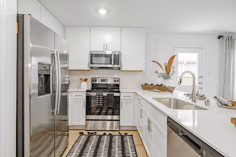 Modern kitchen with stainless steel appliances and granite countertops in Summerwell Wildcat Ranch Home Apartments