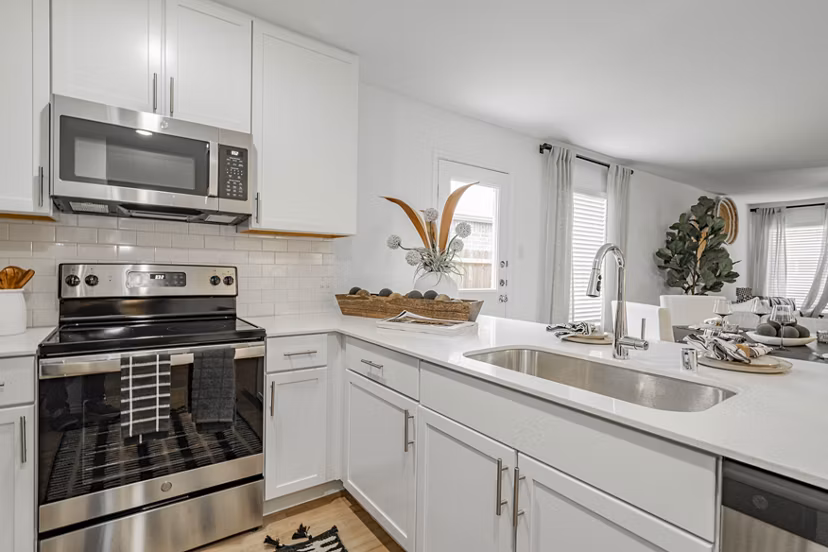 Summerwell Wildcat Ranch Home Apartments: Modern kitchen with stainless steel appliances and island counter