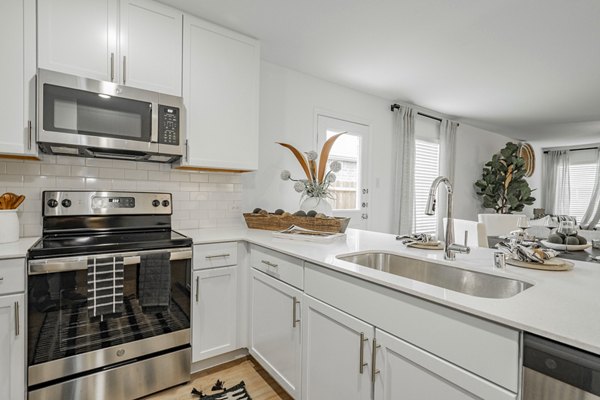 Summerwell Wildcat Ranch Home Apartments: Modern kitchen with stainless steel appliances and island counter