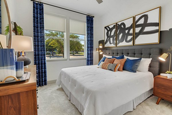 Cozy bedroom with modern furnishings at Stadia Med Main Apartments in a luxury Greystar community