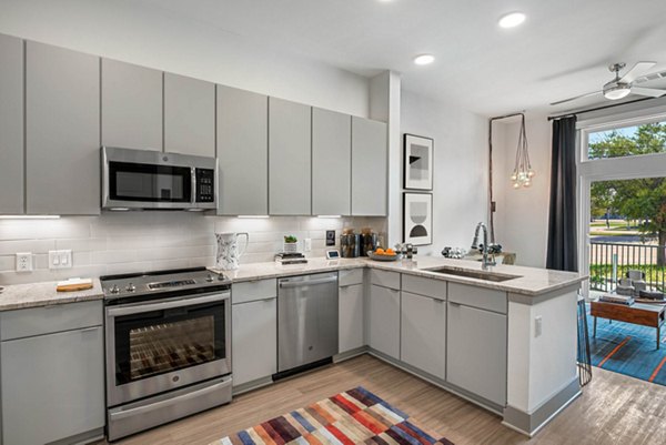 Modern kitchen with sleek cabinetry and stainless steel appliances in Stadia Med Main Apartments, offering luxury living in a prime location