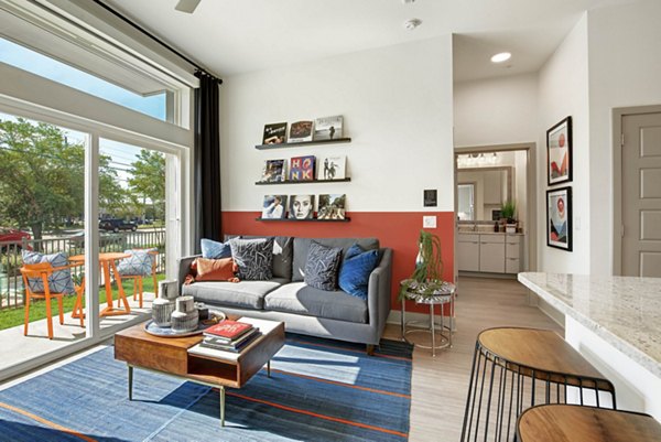 Modern living room with stylish decor and ample natural light at Stadia Med Main Apartments