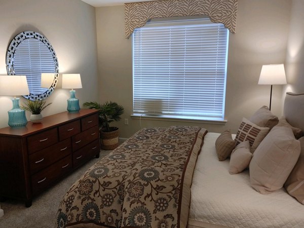 Cozy bedroom featuring modern decor and large windows in Nav850 Apartments