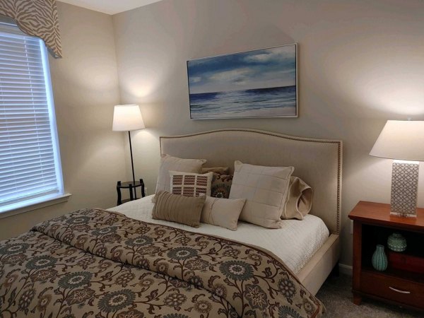 Bedroom with modern decor and large windows at Nav850 Apartments