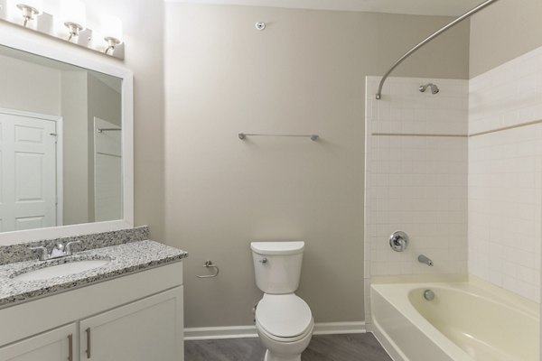 Bathroom featuring modern fixtures and granite countertops in Nav850 Apartments