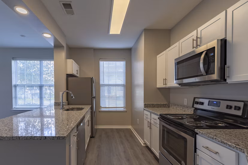 Modern kitchen with stainless steel appliances and granite countertops at Nav850 Apartments