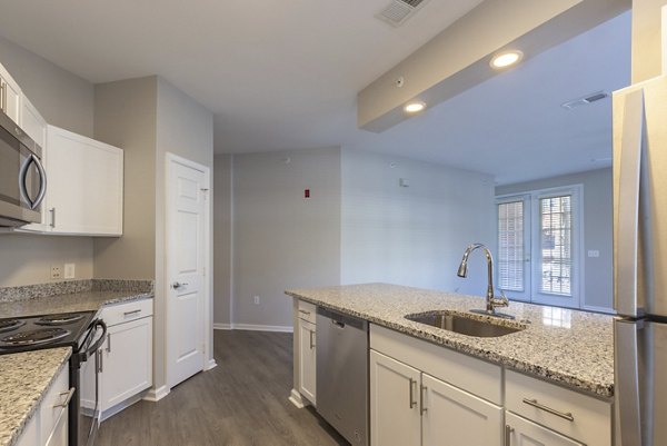 Modern kitchen featuring stainless steel appliances and granite countertops at Nav850 Apartments