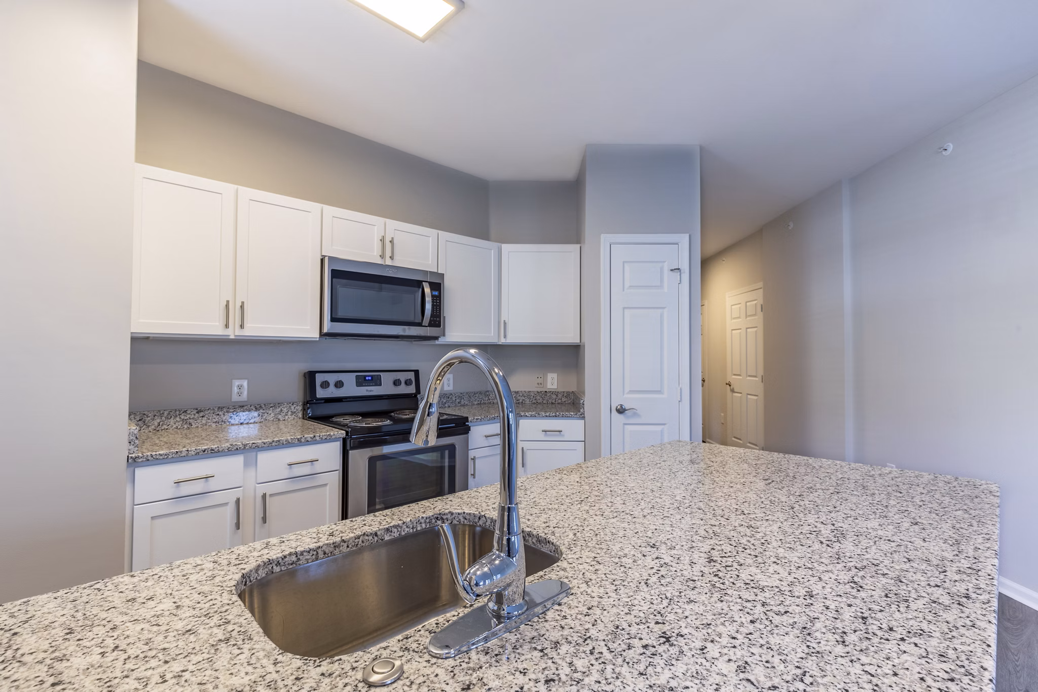Modern kitchen with stainless steel appliances and quartz countertops in Nav850 Apartments