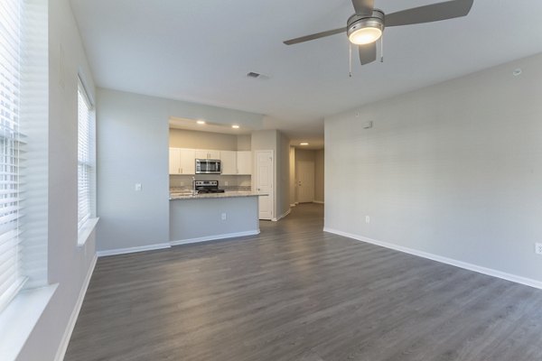 Spacious living room with modern decor and ample lighting in Nav850 Apartments