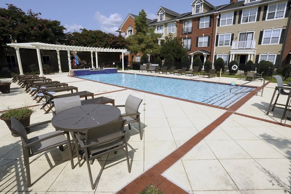 Inviting pool area at Nav850 Apartments with lounge seating and palm trees, perfect for relaxing under the sun
