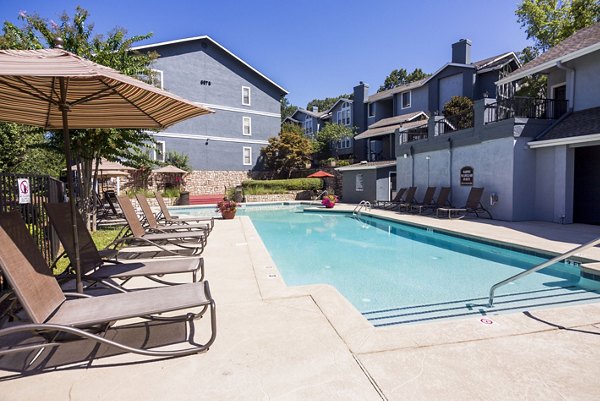 Inviting pool area at Aventura Dunwoody Apartments with relaxing lounge chairs and lush landscaping