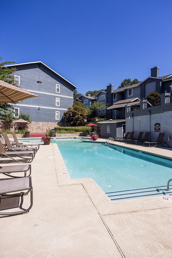 Resort-style pool at Aventura Dunwoody Apartments with sun loungers and lush landscaping
