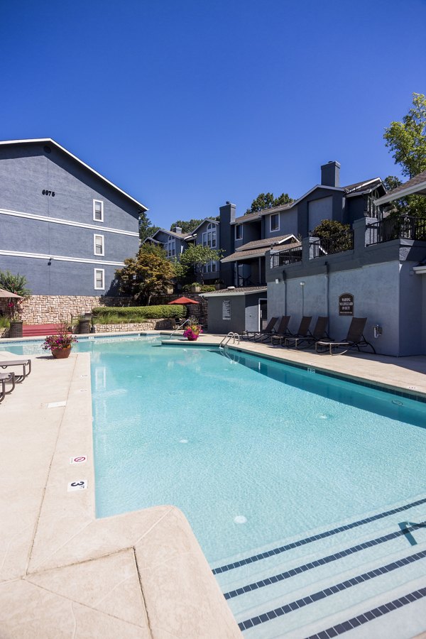 Resort-style pool surrounded by lush landscaping at Aventura Dunwoody Apartments