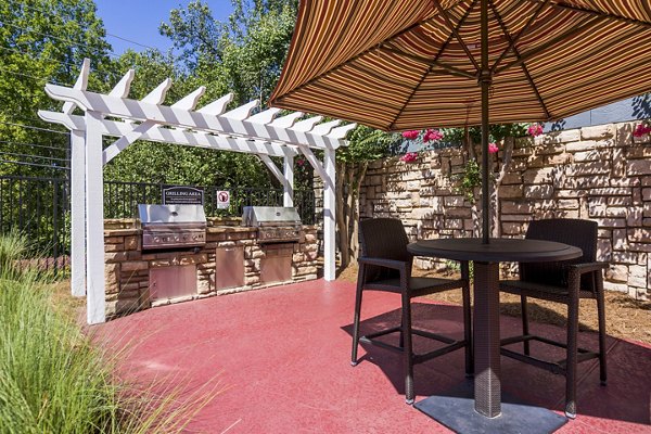Outdoor grill area with modern seating at Aventura Dunwoody Apartments
