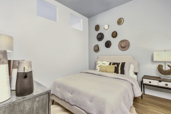 Modern bedroom with sleek furnishings at The Mason at Six Mile Creek Apartments