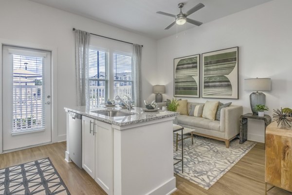 Spacious living room with modern decor and ample natural light at The Mason at Six Mile Creek Apartments