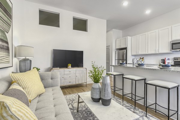 Living room with modern decor and open-space design at The Mason at Six Mile Creek Apartments, luxurious Greystar community in scenic setting