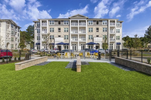 Dog park at The Mason at Six Mile Creek Apartments featuring lush green space for resident pets