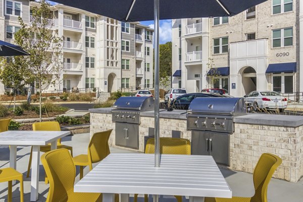 Outdoor grill area with modern seating at The Mason at Six Mile Creek Apartments, perfect for social gatherings and barbecues