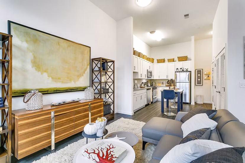 Modern living room featuring elegant furniture and large windows at Harbor Landing Apartments