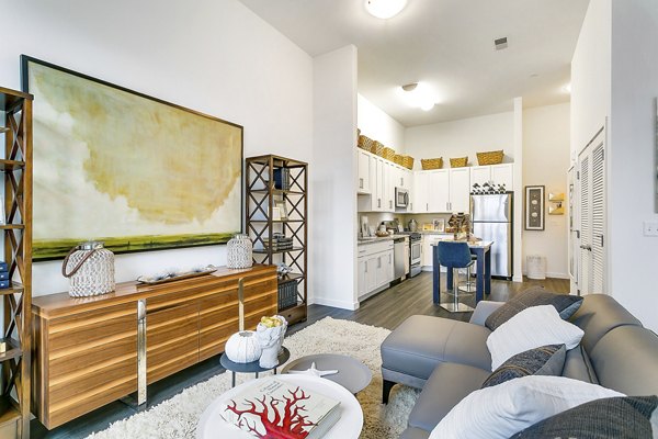Modern living room featuring elegant furniture and large windows at Harbor Landing Apartments