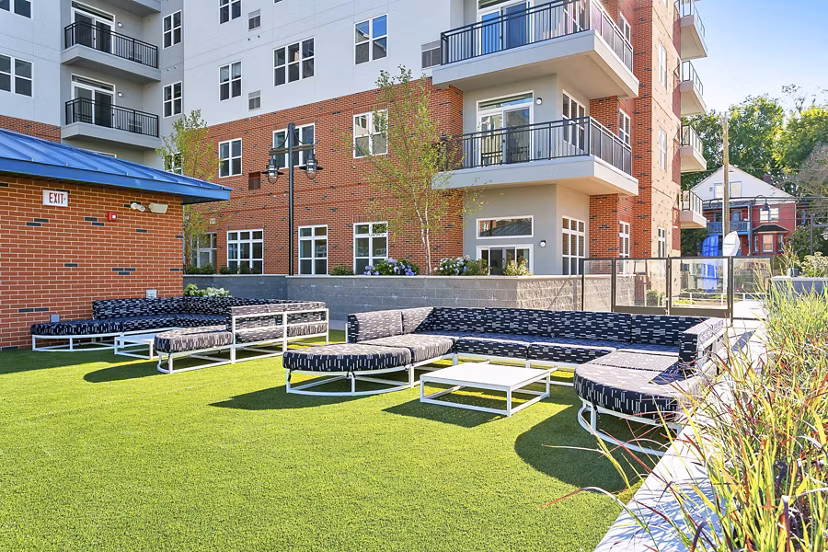 Courtyard with lush greenery and seating areas at Harbor Landing Apartments in a luxury Greystar community