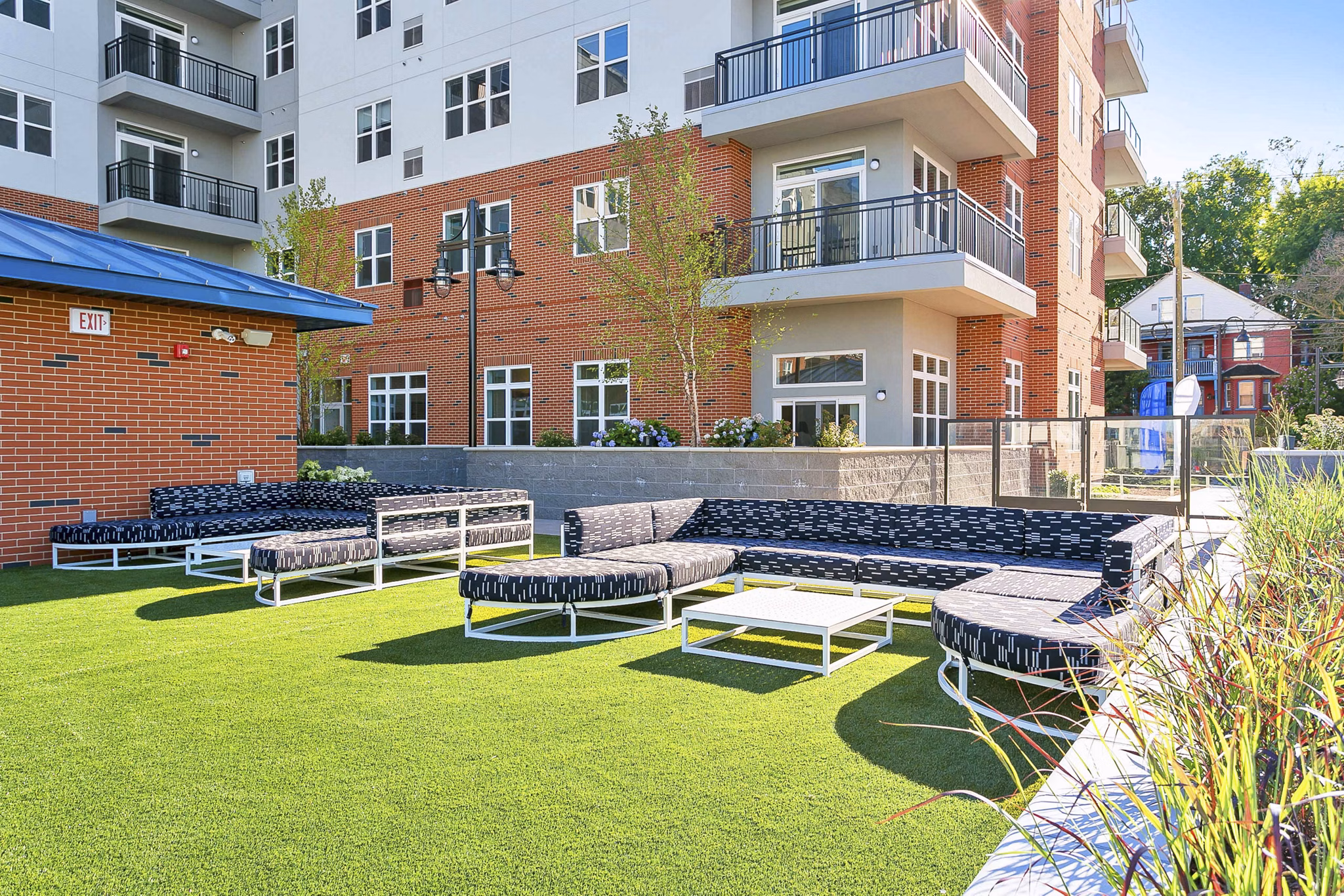 Courtyard with lush greenery and seating areas at Harbor Landing Apartments in a luxury Greystar community