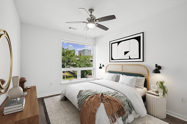 Modern bedroom featuring a cozy bed, nightstand, and wall art in luxury apartment setting