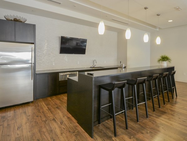 Clubhouse with modern design and lounge seating at 75 Tresser Apartments in a vibrant urban setting